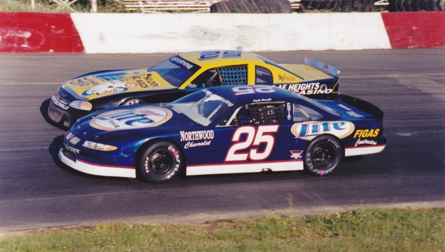 Angelo drives underneath Ronnie O'Neill in his 2002 Track Champion Miller Lite car